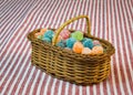 Sugar coated jelly sweets in wicker basket on striped tablecloth