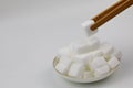 White rock sugar cubes on a plate food table dessert on white background close up watch out of diabetes,a piece of sugar in a bam