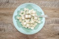 Sugar cubes in a plate and spoon on a wooden background. Sugar harm concept. Eat sugar with a spoon. Royalty Free Stock Photo