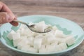 Sugar cubes in a plate and spoon on a wooden background. Sugar harm concept. Eat sugar with a spoon. Royalty Free Stock Photo