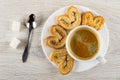 Sugar, spoon, puff cookies with poppy, black coffee in cup on plate on wooden table. Top view Royalty Free Stock Photo