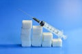 Sugar cubes with syringe. Diabetes concept. The concept of possible harm from sugar. Increase in blood sugar levels, the graph of