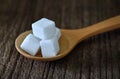 Sugar cubes in wood spoon on wood table Royalty Free Stock Photo
