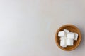 Sugar cubes in a wooden plate on the kitchen table. On right side of the photo. Top view. With copy space Royalty Free Stock Photo