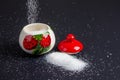 Sugar explosion in a sugar bowl with strawberries on a black background