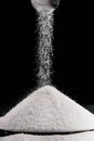 sugar falling from metal scoop on pile on plate Royalty Free Stock Photo