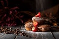 Sugar falling on muffins with strawberries laid on a jute bag with coffee beans. Royalty Free Stock Photo