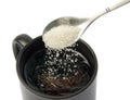 Sugar falling from spoon into a cup