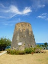 Sugar Mill in garden with bright blue sky and blue ocean behind Royalty Free Stock Photo