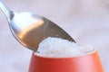 Sugar in a orange bowl spooned with silver spoon Royalty Free Stock Photo