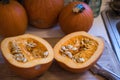 Sugar pumpkin cut in half exposing the pulp and seeds