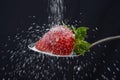 Sugar rain sprinkle over delicious strawberry on spoon spilling out everywhere