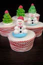 Sugar snowmen figurines on glazed muffins Royalty Free Stock Photo