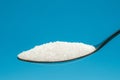 Sugar spoon blue background. Royalty Free Stock Photo