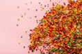 Colorful sprinkles scattered on pink background Royalty Free Stock Photo