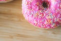 Sugar addiction: Close up of sugar sprinkled pink donut Royalty Free Stock Photo