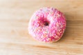 Sugar addiction: Close up of sugar sprinkled pink donut Royalty Free Stock Photo