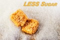 Less sugar text. Cubes of yellow sugar lying on a background of white sugar. Diet and health concepts