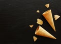 Sugar waffle cones on black coal background, selective focus