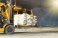 Sugar warehouse activities, forklift carries sugar bags to container stuffing area for export. Industrial logistics concept.
