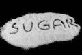 Sugar word written on white sugar