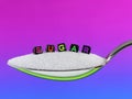 SUGAR, written with mulicolour letters, on silver spoon isolated on purple background Royalty Free Stock Photo