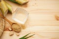 Sugarcane, fresh cane juice and brown sugar on a wooden background, space for text. Top view