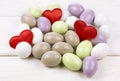 Sugared almonds with red heart shaped confetti