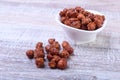 Sugared Hazelnuts in a white bowl on a wooden background. Hazelnuts in sugar glaze. Selective focus. Royalty Free Stock Photo