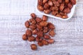 Sugared Hazelnuts in a white bowl on a wooden background. Hazelnuts in sugar glaze. Selective focus. Royalty Free Stock Photo