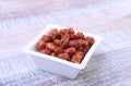 Sugared Hazelnuts in a white bowl on a wooden background. Hazelnuts in sugar glaze. Selective focus. Royalty Free Stock Photo