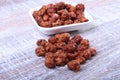 Sugared Hazelnuts in a white bowl on a wooden background. Hazelnuts in sugar glaze. Selective focus. Royalty Free Stock Photo