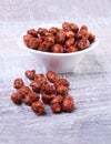 Sugared Hazelnuts in a white bowl on a wooden background. Hazelnuts in sugar glaze. Selective focus. Royalty Free Stock Photo