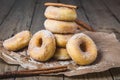 Sugared stacked mini donuts with cinnamon on a wooden table