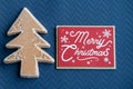 Sugary gingerbread cookie tree on a blue background with a Merry Christmas plaque, useful for Christmas holiday projects Royalty Free Stock Photo