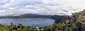 Suggestive overview at Albano Lake with Castel Gandolfo city skyline the wooded slopes of volcanic caldera wrapped in a fantastic