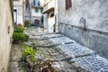 Suggestive pathway of the Italian village of Tolfa in the Lazio Region with flower beds that surround the ancient road paved with Royalty Free Stock Photo