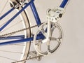 Sugino crankset, pedal and chain on a sporty blue bicycle.