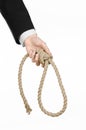 Suicide and business topic: Hand of a businessman in a black jacket holding a loop of rope for hanging on white isolated