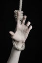 Suicide and depression topic: human hand hanging on rope loop on a black background Royalty Free Stock Photo