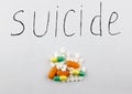 A suicide handful of pills on a white background suicide