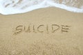 SUICIDE written on sand