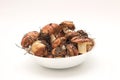 Suillus mushrooms in a ceramic soup plate isolated on a white background. Armful of dirty, unpeeled, butter fungi