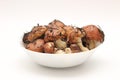 Suillus mushrooms in a ceramic soup plate isolated on a white background. Armful of dirty, unpeeled, butter fungi