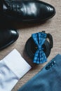 Suit, blue bow tie, leather black shoes and belt. Grooms wedding morning. Close up of modern man accessories Royalty Free Stock Photo