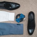 Suit, blue bow tie, leather black shoes and belt. Grooms wedding morning. Close up of modern man accessories