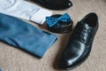 Suit, blue bow tie, leather black shoes and belt. Grooms wedding morning. Close up of modern man accessories Royalty Free Stock Photo