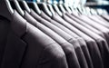 Suit jackets in hanger in men fashion and apparel store. Row of many clothes in rack or wardrobe. New stylish collection. Royalty Free Stock Photo