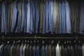 Suit jackets in hanger in men fashion and apparel store. Row of many clothes in rack or wardrobe. Royalty Free Stock Photo