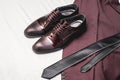 Suit, necktie, leather shoes on a white textile. Grooms wedding morning. Close up of modern man accessories